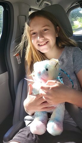 Elynn holding her stuffed animal in the car